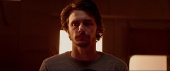 Movie still from “This Is the End” (2013), directed by Seth Rogen – A person wearing a gray t - shirt; Close Up shot, Low angle