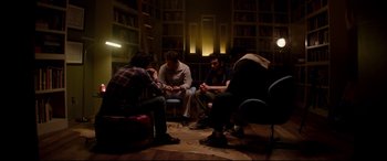 Movie still from “This Is the End” (2013), directed by Seth Rogen – A group of people sitting in a circle in a room; Wide shot, High angle