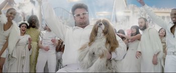 Movie still from “This Is the End” (2013), directed by Seth Rogen – A man holding a brown and white dog in his arms; Medium shot, Low angle