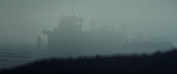 Movie still from “The Colony” (2021), directed by Tim Fehlbaum – A group of people standing on top of a boat in the water; Extreme Wide shot, Low angle