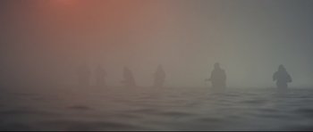 Movie still from “The Colony” (2021), directed by Tim Fehlbaum – A group of people standing on top of a body of water; Extreme Wide shot, Low angle