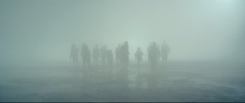 Movie still from “The Colony” (2021), directed by Tim Fehlbaum – A group of people walking through the fog; Extreme Wide shot, High angle