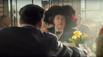 Movie still from “Titanic” (1997), directed by James Cameron – A woman in a black hat is looking in the mirror; Medium shot, Over the shoulder angle