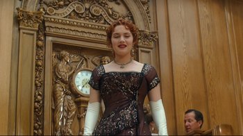Movie still from “Titanic” (1997), directed by James Cameron – A woman with red hair in a black dress and white gloves; Medium shot, Low angle