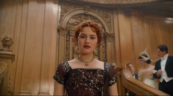 Movie still from “Titanic” (1997), directed by James Cameron – A woman with red curly hair wearing a black dress; Medium shot, Low angle