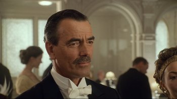 Movie still from “Titanic” (1997), directed by James Cameron – A person wearing a suit and a bow tie; Close Up shot, Low angle