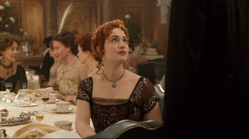 Movie still from “Titanic” (1997), directed by James Cameron – A group of people sitting around a table; Medium shot, Over the shoulder angle