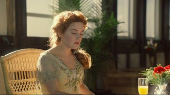 Movie still from “Titanic” (1997), directed by James Cameron – A beautiful woman with red hair wearing a white dress; Medium shot, Over the shoulder angle