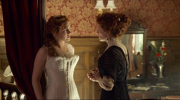Movie still from “Titanic” (1997), directed by James Cameron – Two women dressed in period clothing talking to each other; Medium shot, Over the shoulder angle