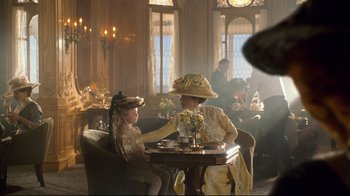 Movie still from “Titanic” (1997), directed by James Cameron – Two people sitting at a table in a room; Medium shot, Over the shoulder angle