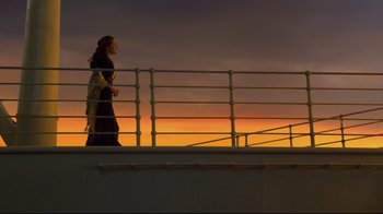 Movie still from “Titanic” (1997), directed by James Cameron – A woman standing on top of a boat at sunset; Wide shot, Low angle