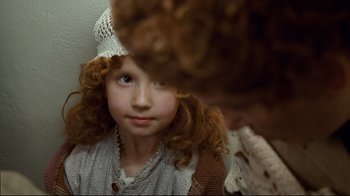 Movie still from “Titanic” (1997), directed by James Cameron – A little girl wearing a white hat looking at the camera; Close Up shot, Over the shoulder angle