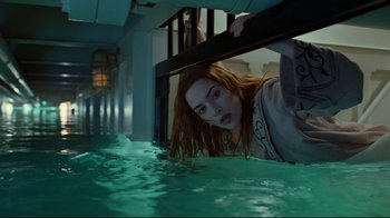 Movie still from “Titanic” (1997), directed by James Cameron – A woman is leaning against a railing in the water; Medium shot, Overhead angle