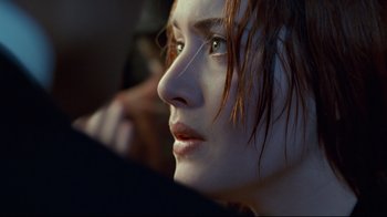 Movie still from “Titanic” (1997), directed by James Cameron – A woman's face with red hair and green eyes; Close Up shot, Over the shoulder angle