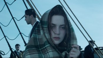 Movie still from “Titanic” (1997), directed by James Cameron – A woman wrapped in a blanket standing next to a man on a boat; Close Up shot, Low angle