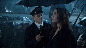 Movie still from “Titanic” (1997), directed by James Cameron – A man and a woman under an umbrella in the rain; Medium shot, Over the shoulder angle