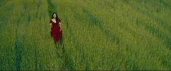 Movie still from “To All the Boys I've Loved Before” (2018), directed by Susan Johnson – A woman in a red dress standing in a green field; Extreme Wide shot, High angle