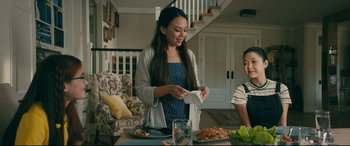 Movie still from “To All the Boys I've Loved Before” (2018), directed by Susan Johnson – A woman and a child sitting at a dining table; Medium shot, Over the shoulder angle