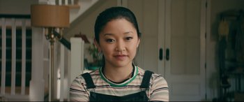 Movie still from “To All the Boys I've Loved Before” (2018), directed by Susan Johnson – A young woman wearing a striped shirt is posing for a picture; Close Up shot, Over the shoulder angle