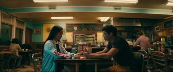 Movie still from “To All the Boys I've Loved Before” (2018), directed by Susan Johnson – A man and a woman sitting at a table in a restaurant; Medium shot, Over the shoulder angle