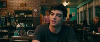 Movie still from “To All the Boys I've Loved Before” (2018), directed by Susan Johnson – A man sitting in front of a woman in a room; Close Up shot, Over the shoulder angle