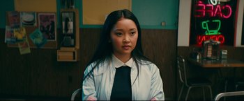 Movie still from “To All the Boys I've Loved Before” (2018), directed by Susan Johnson – A woman in a white shirt and a black tie; Close Up shot, High angle