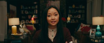 Movie still from “To All the Boys I've Loved Before” (2018), directed by Susan Johnson – A woman with long black hair is smiling for the camera; Medium shot, Over the shoulder angle