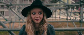 Movie still from “To All the Boys I've Loved Before” (2018), directed by Susan Johnson – A woman wearing a black hat and a leather jacket; Close Up shot, Over the shoulder angle