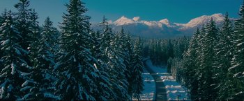 Movie still from “To All the Boys I've Loved Before” (2018), directed by Susan Johnson – A snowy mountain with a road going through it; Extreme Wide shot, High angle
