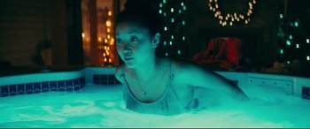 Movie still from “To All the Boys I've Loved Before” (2018), directed by Susan Johnson – A woman laying in a pool of water at night; Medium shot, Over the shoulder angle