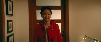 Movie still from “To All the Boys I've Loved Before” (2018), directed by Susan Johnson – A woman in a red coat standing in front of a door; Medium shot, Over the shoulder angle