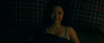 Movie still from “To All the Boys I've Loved Before” (2018), directed by Susan Johnson – A woman sitting in a chair in the dark; Close Up shot, High angle