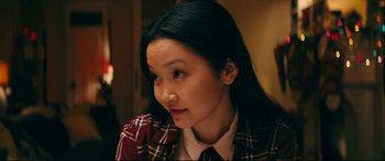 Movie still from “To All the Boys I've Loved Before” (2018), directed by Susan Johnson – A young woman with long black hair wearing a plaid shirt; Close Up shot, Over the shoulder angle