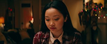 Movie still from “To All the Boys I've Loved Before” (2018), directed by Susan Johnson – A young asian woman in a red and white plaid shirt; Close Up shot, Over the shoulder angle