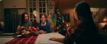 Movie still from “To All the Boys I've Loved Before” (2018), directed by Susan Johnson – Two people sitting at a table with a christmas tree in the background; Medium shot, Over the shoulder angle