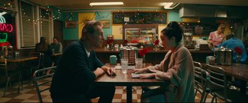 Movie still from “To All the Boys I've Loved Before” (2018), directed by Susan Johnson – A man and a woman sitting at a table in a restaurant; Medium shot, Over the shoulder angle