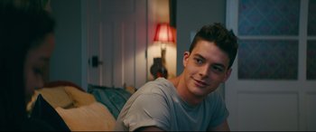 Movie still from “To All the Boys I've Loved Before” (2018), directed by Susan Johnson – A man sitting on a bed in a room; Close Up shot, Over the shoulder angle
