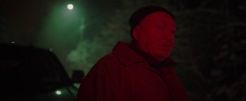 Movie still from “To the Lake” (2019), directed by Pavel Kostomarov – An older man wearing a red coat and a black hat; Close Up shot, Over the shoulder angle
