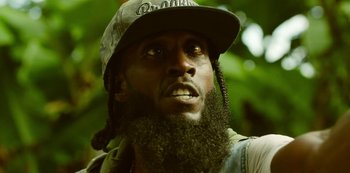 Movie still from “Top Boy” (2011), created by Ronan Bennett – A person with a beard and a hat; Close Up shot, Low angle