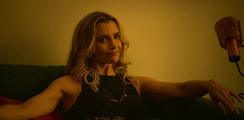 Movie still from “Top Boy” (2011), created by Ronan Bennett – A woman sitting on a couch in front of a wall; Close Up shot, Low angle