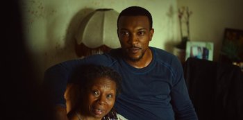 Movie still from “Top Boy” (2011), created by Ronan Bennett – A man and a woman pose for a picture; Close Up shot, High angle