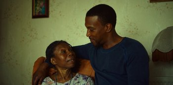 Movie still from “Top Boy” (2011), created by Ronan Bennett – An older woman sitting next to a young man; Close Up shot, Over the shoulder angle