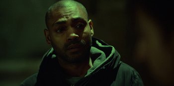 Movie still from “Top Boy” (2011), created by Ronan Bennett – A person wearing a hooded sweatshirt; Close Up shot, High angle