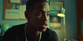 Movie still from “Top Boy” (2011), created by Ronan Bennett – A person wearing a black shirt; Close Up shot, Over the shoulder angle