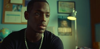 Movie still from “Top Boy” (2011), created by Ronan Bennett – A person wearing a black shirt; Close Up shot, Over the shoulder angle