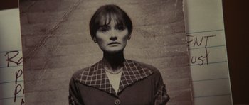 Movie still from “Shutter Island” (2010), directed by Martin Scorsese – A woman in a black and white checkered shirt; Close Up shot, High angle