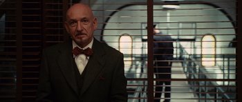 Movie still from “Shutter Island” (2010), directed by Martin Scorsese – A man in a suit and bow tie standing in front of a window; Close Up shot, Low angle