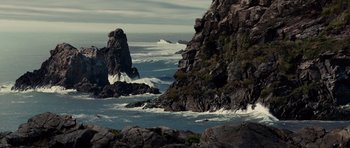 Movie still from “Shutter Island” (2010), directed by Martin Scorsese – A body of water surrounded by rocks and water; Extreme Wide shot, High angle