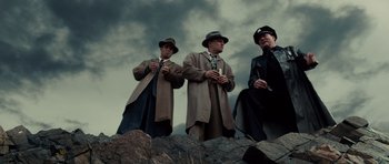 Movie still from “Shutter Island” (2010), directed by Martin Scorsese – A group of men standing next to each other on top of a hill; Wide shot, Low angle