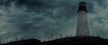 Movie still from “Shutter Island” (2010), directed by Martin Scorsese – A person standing on top of a hill under a cloudy sky; Extreme Wide shot, Low angle